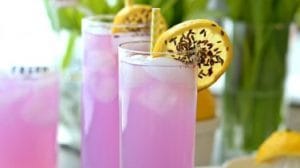 Buz dolu bir bardakta, taze nane yaprakları ve limon dilimleri ile süslenmiş lavantalı limonata