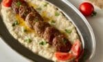Fırında közlenmiş patlıcan püresi ve beşamel sos ile hazırlanan beğendi üzerinde, az yağlı tavada pişirilmiş, lokum kıvamında köfteler servis ediliyor.
