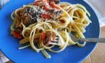 Kremalı sebzeli fettuccine makarna, yanında erimiş kaşar peyniri ile servis ediliyor.