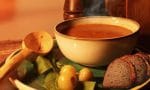 Bir kasede sıcak tarhana çorbası, yanında bir dilim ekmek.
