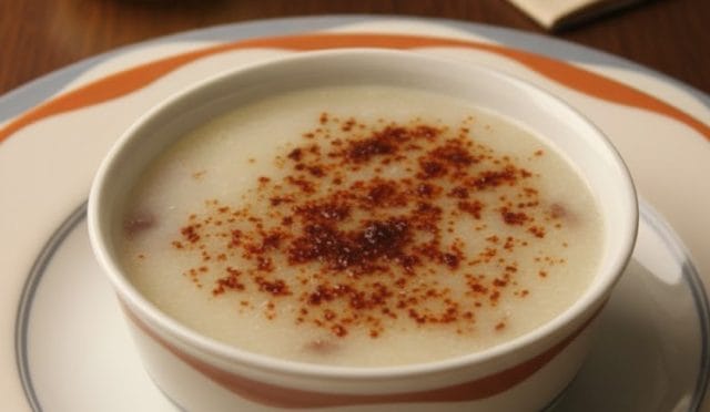 Porselen kasede servis edilen, üzerine pul biber serpilmiş, pürüzsüz kıvamlı ve sarımsaklı soslu şifalı kelle paça çorbası.