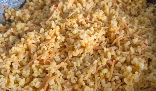 Tane tane dökülen, tereyağlı ve kavrulmuş tel şehriyeli bulgur pilavı tabağı