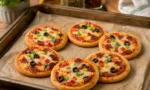 Fırından yeni çıkmış, üzeri bol kaşarlı ve malzemeli, puf puf kabarmış porsiyonluk pizzalar
