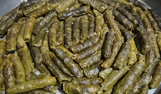 Nar ekşisi gezdirilmiş, parlak ve iştah açıcı görünen, tencereden bir tepsiye ters çevrilmiş asma yaprağı sarmaları