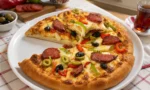 Fırından yeni çıkmış, üzeri sucuk, biber, zeytin ve erimiş kaşarla kaplı dondurucuya uygun ev yapımı pizza dilimi.