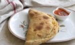Fırından yeni çıkmış, içi peynirli ve domates soslu kapalı pizza – calzone