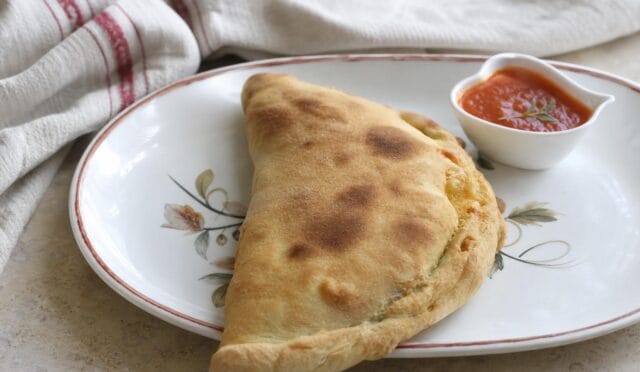 Fırından yeni çıkmış, içi peynirli ve domates soslu kapalı pizza – calzone