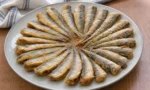 Tavada çıtır mısır unu kaplamalı sardalyalar, yanında limon ve yeşilliklerle servis edilmiş