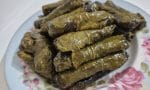 Limon dilimleriyle servis edilen zeytinyağlı asma yapmağı sarması