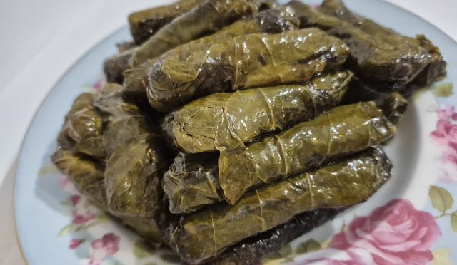 Limon dilimleriyle servis edilen zeytinyağlı asma yapmağı sarması