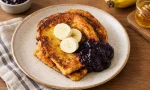 Muz, yaban mersini, bal ve pudra şekeriyle servis edilen French toast
