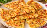 Krep pizza tarifi için hazırlanan, peynir, zeytin ve renkli biberlerle süslenmiş ev yapımı pizza görseli.